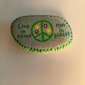 Hand painted peace sign on river rock